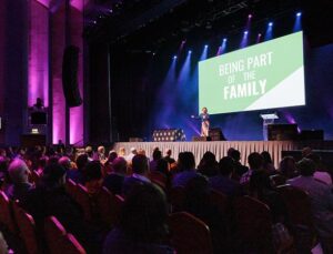 An audience sat in Troxy Auditorium looking up to the stage as someone presents an award.